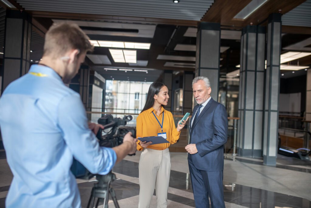 Asian Female Reporter Standing Next To Grey Haired 2024 10 18 04 14 26 Utc 1024x683